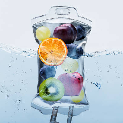 Close-up Of Various Fruit Slices In Saline Bag Dip In Water Against White Background